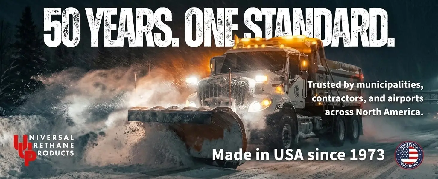 Universal Urethane snow plow truck clearing a highway at night — 50 years, made in the USA since 1973, trusted by municipalities, contractors, and airports.